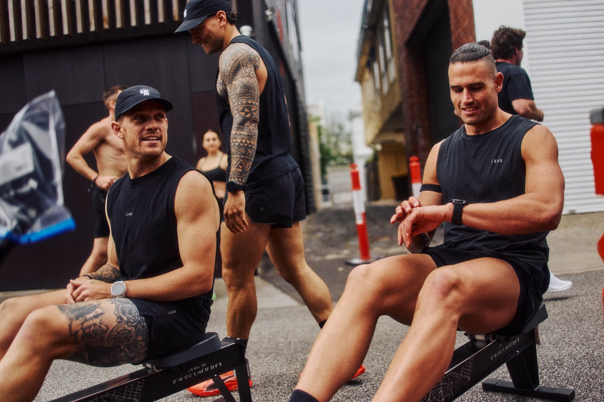Athletes resting on rowers between stations